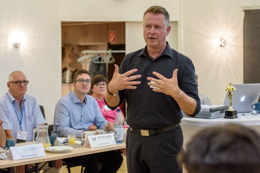 Rhetoriktrainer Ike Fast lehrt aktives Zuhören vor interessierten Zuhörern im Raum.